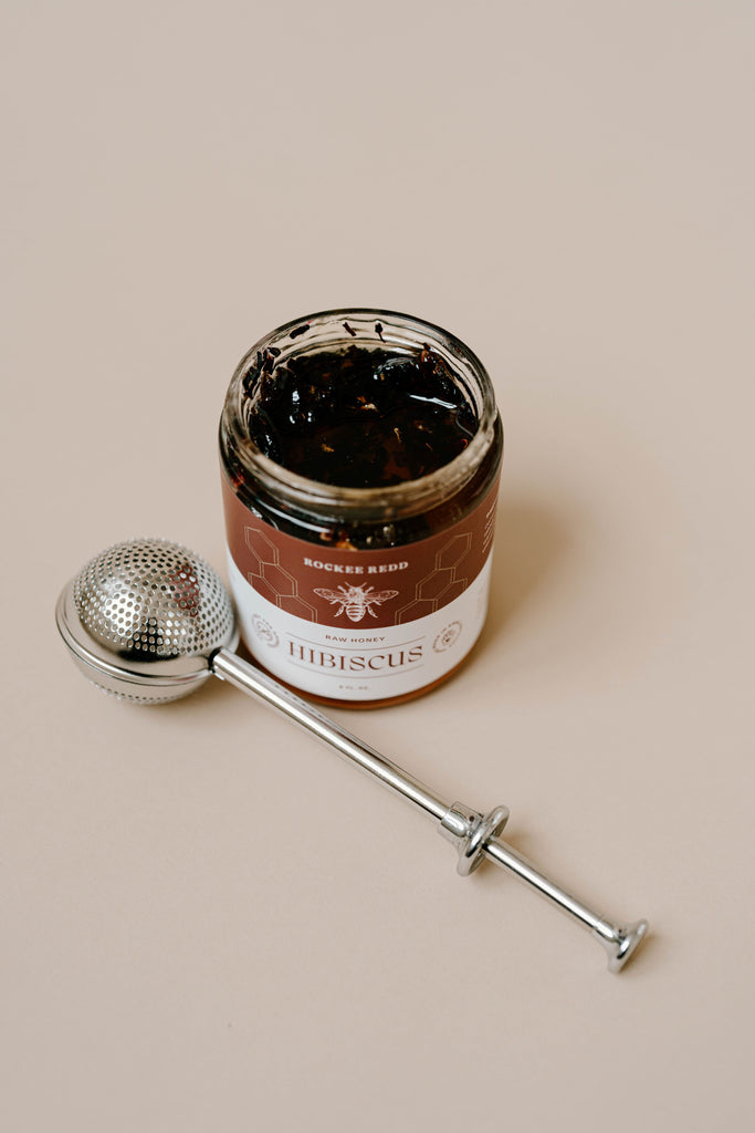Opened Rockee Redd Hibiscus honey jar with tea infuser